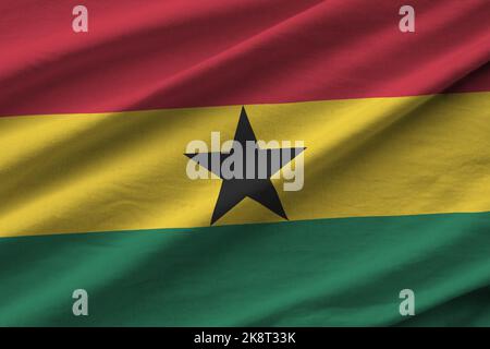 Ghana flag with big folds waving close up under the studio light indoors. The official symbols and colors in fabric banner Stock Photo