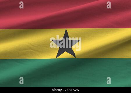 Ghana flag with big folds waving close up under the studio light indoors. The official symbols and colors in fabric banner Stock Photo