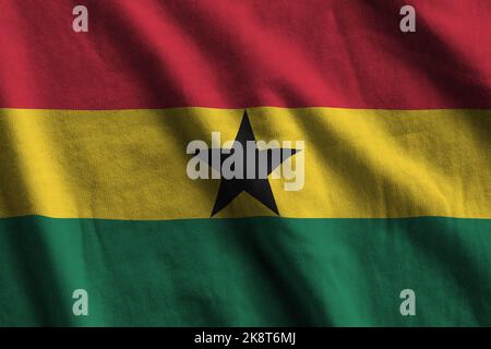 Ghana flag with big folds waving close up under the studio light indoors. The official symbols and colors in fabric banner Stock Photo