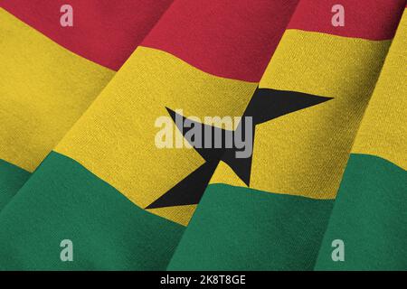 Ghana flag with big folds waving close up under the studio light indoors. The official symbols and colors in fabric banner Stock Photo