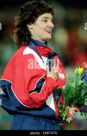 Hamar 1994-02-19 Olympic Games 1994 Lillehammer. Quick races, women, 500 meters. Bonnie Blair (USA) on the victory podium. She took gold. Here, the medal blows, while she sings the national anthem and holds her hand over her heart. Photo: Lise Åserud / NTB / NTB Stock Photo