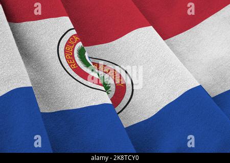 Paraguay flag with big folds waving close up under the studio light indoors. The official symbols and colors in fabric banner Stock Photo