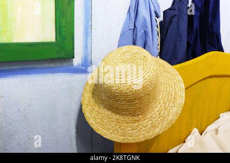 a straw hat is hanging on the bed Stock Photo