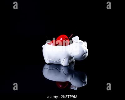 A close up shot of ceramic vase in the form of a dog with apples The porcelain vase has fluted surface. The vase with a bunch is isolated against the Stock Photo
