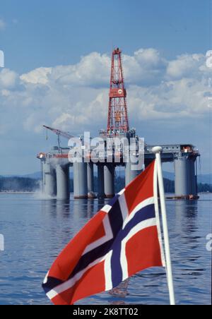 Oslo June 1974: The oil drilling platform Odin Drill (Aker H3 platform) is being built at Nyland's workshop. Here the platform at the Port of Oslo. Norwegian flag in the foreground, blue sky in the background. Illustration: The story of the Norwegian oil adventure. Photo: Erik Thorberg / NTB / NTB Stock Photo