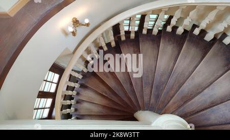 Antique brown wooden spiral staircase. Stock Photo