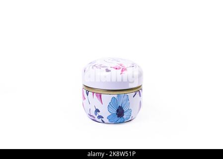 A close up shot of metallic vase jar with white red blue flowers . The porcelain vase has fluted surface. The vase with a bunch is isolated against th Stock Photo