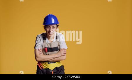 Portrait of empowered female constructor searching for something in studio, acting curious and looking surprised. Exploring and investigating unbelievable things, silly curiosity. Stock Photo