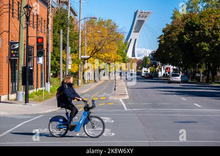 Montreal, CA - 10 October 2022: Woman riding a Bixi bike on Rachel street in Autumn Stock Photo