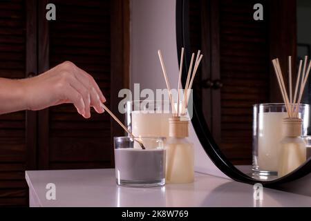 A woman's hand lights scented candles with a match. Romantic dinner. On a dark background. Vertical video Stock Photo