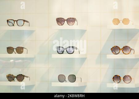 Exhibitor of glasses consisting of shelves of fashionable glasses shown on a wall at the optical shop Stock Photo