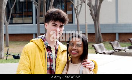 Diverse smiling young teenage couple friends or boyfriends looking at camera Stock Photo