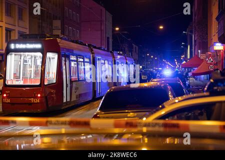 Nuremberg, Germany. 24th Oct, 2022. A police cordon hangs in front of a crime scene after shots were fired here. In the background, police officers stand next to a streetcar near the scene of the crime. One man died and another was seriously injured in shots fired in Nuremberg's Südstadt district this evening. The homicide squad has started investigations into the background of the incident. Credit: Daniel Karmann/dpa/Alamy Live News Stock Photo