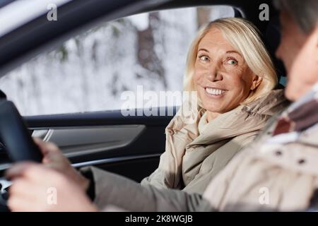 Portrait of smiling mature woman enjoying car ride with husband in winter Stock Photo