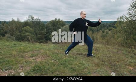 Caucasian man is engaged traditional Chinese gymnastics qigong and tai chi Stock Photo