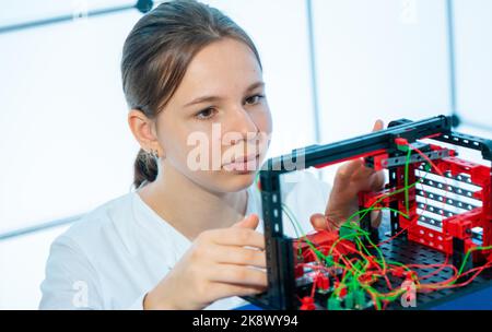 Young woman student assembling electronic devices in the robotics laboratory Stock Photo