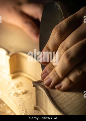 smoothing fiddle table on maker workbench Stock Photo