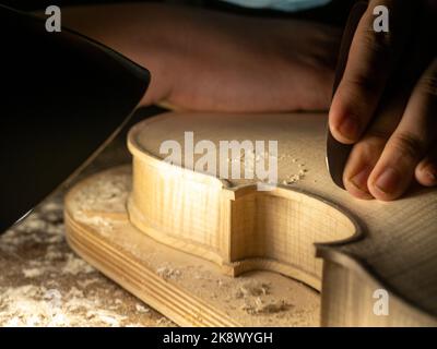 smoothing fiddle table on maker workbench Stock Photo