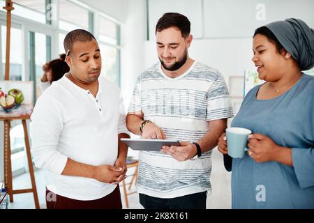 I thought this might be something you would like. a diverse group of friends standing together and using a tablet during an art class. Stock Photo