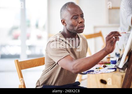 To paint is to show a bit of your soul. a man painting in a art studio. Stock Photo