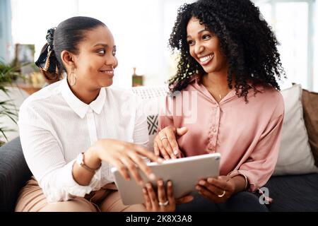 Technology, the people connector. two young businesswomen using a digital tablet in a modern office. Stock Photo