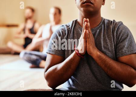 Tomorrow depends on what you do today. a group of young men and women meditating in a yoga class. Stock Photo