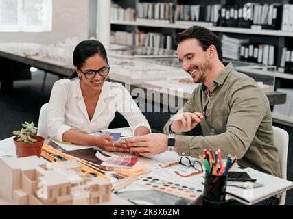 Im really proud of our work. two aspiring young architects smiling while working together in a modern office. Stock Photo
