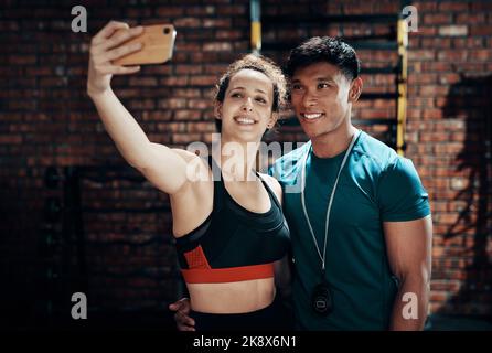 Cant leave the gym without a selfie. two young sportspeople taking a selfie together in a gym. Stock Photo