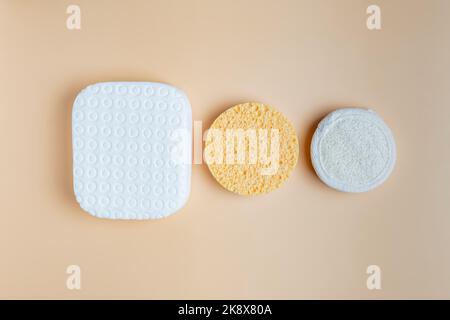 set of different sponges for the face. Cleansing and exfiliating sponges on beige background. Skin care concept Stock Photo