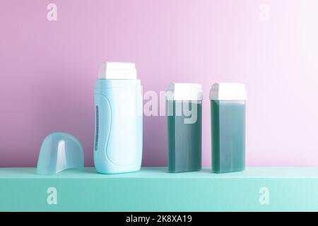 Depilation equipment standing on decorative podium. Portable depilatory heater with wax roll-on cartridges, beauty treatment concept, copy space. Stock Photo