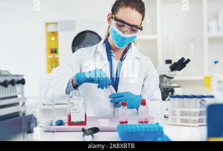 Got to make sure its properly closed. an unrecognizable young female scientist wearing protective fave gear while conducting experiments inside of a Stock Photo