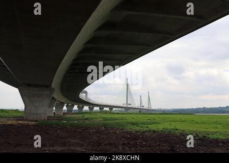 The Mersey Gateway Bridge curves away to cross the River Mersey and the Manchester Ship canal between Widnes and Runcorn, seen from underneath Stock Photo