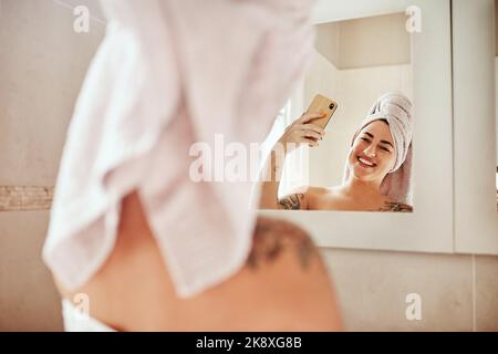 Me at my best. a young woman taking a selfie while going through her morning beauty routine. Stock Photo