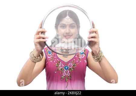 Indian woman holding Karwa Chauth strainer and Diya oil lamps for the Karwa Chauth celebration isolated over white background Stock Photo
