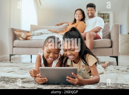 Children, tablet or relax parents in living room of house or family home for education video, movie streaming or internet esports. Smile, happy or Stock Photo