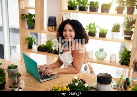 Im running my entire store online. High angle portrait of an attractive young female botanist working on a laptop in her florist. Stock Photo