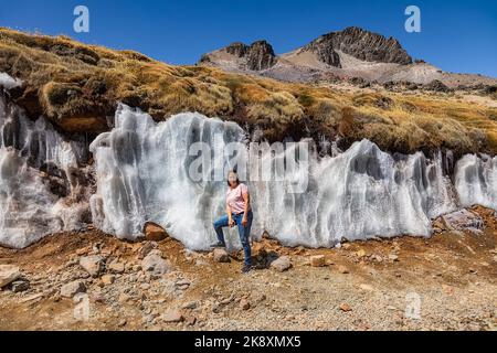 A tourist stands in front of the Jaruma Ice Walls, located exactly on the route between Arequipa and Chivay. Stock Photo