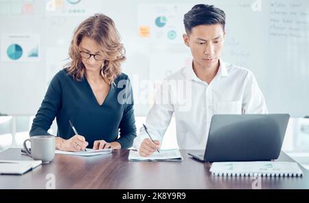 Notes, marketing and employees, planning, meeting and working with a laptop in partnership in an office at work. Corporate workers writing strategy Stock Photo
