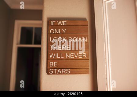 Keep your chin up. a motivational quote hanging on a wall. Stock Photo