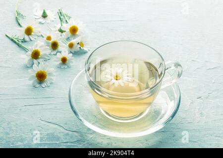 Chamomile tea. Camomile infusion in a cup with a tea pot, natural remedy, with fresh flowers Stock Photo