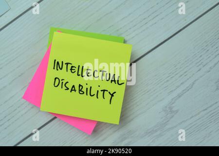 Concept of Intellectual Disability write on sticky notes isolated on Wooden Table. Stock Photo