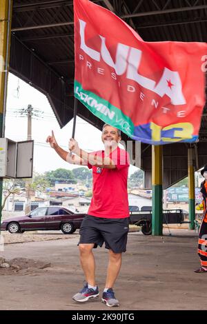 Goiânia, Goias, Brazil – October 21, 2022: A man walking holding a Lula flag. Image made in an act to ask for votes for Lula. Stock Photo