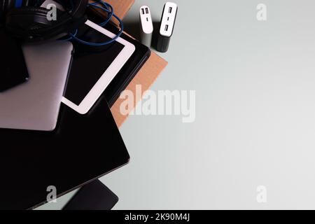 Cardboard box full of old used laptop computers, digital tablets, smartphones, power bank for recycling on gray background. Donation, e-waste Stock Photo