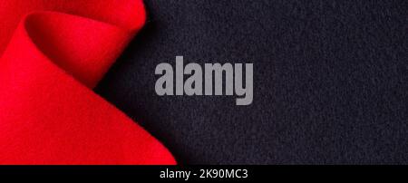 Abstract geometric wool felt texture background. Creative geometric curved red color felt material on black felt textile background. Top view, copy Stock Photo