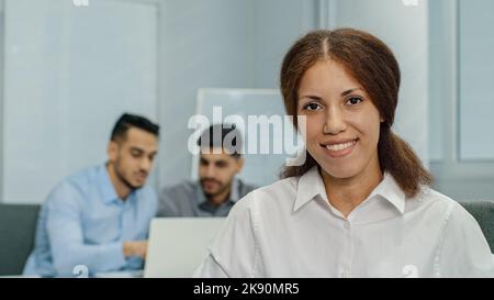 Smiling female leader manager coach speaker looking at camera. Friendly businesswoman greeting or welcoming new worker in modern business office with Stock Photo