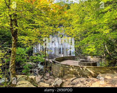 A view of Carbide Willson Ruins and a bridge in a lush green forest, Gatineau Park, Chelsea, Quebec, Canada Stock Photo