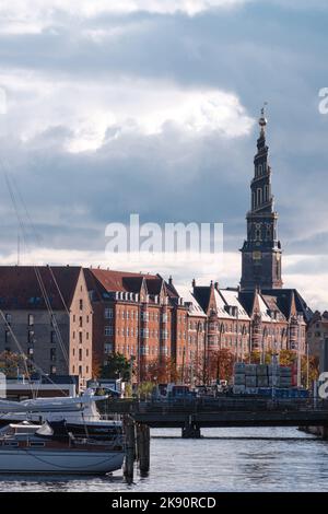 Copenhagen, Denmark - Sept 2022: View over canal in the city lined with historical buildings in Christianshavn neighborhood and the tip of the Church Stock Photo