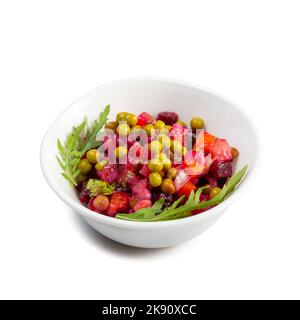 Vinaigrette salad with boiled vegetables, pickled cucumbers, sauerkraut and canned green peas in white bowl isolated on white. Traditional Russian sna Stock Photo