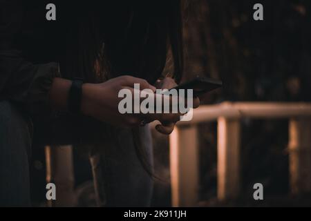 A closeup shot of male hands typing on a smartphone Stock Photo