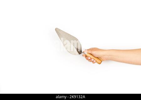 Woman hand holding a bricklayer trowel on a white background with copy space Stock Photo